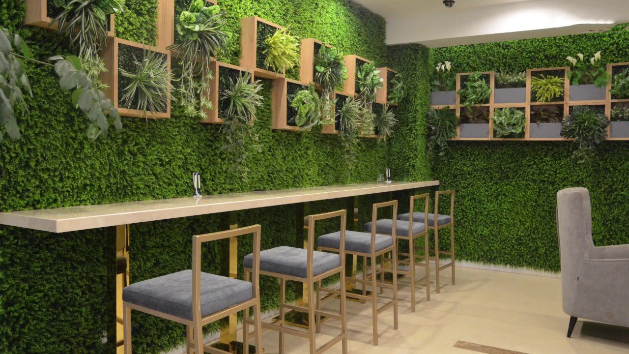 Thảm cỏ nhân tạo trên tường biến bức tường trở thành một góc xanh, tươi mát trong quán cà phê của bạn.